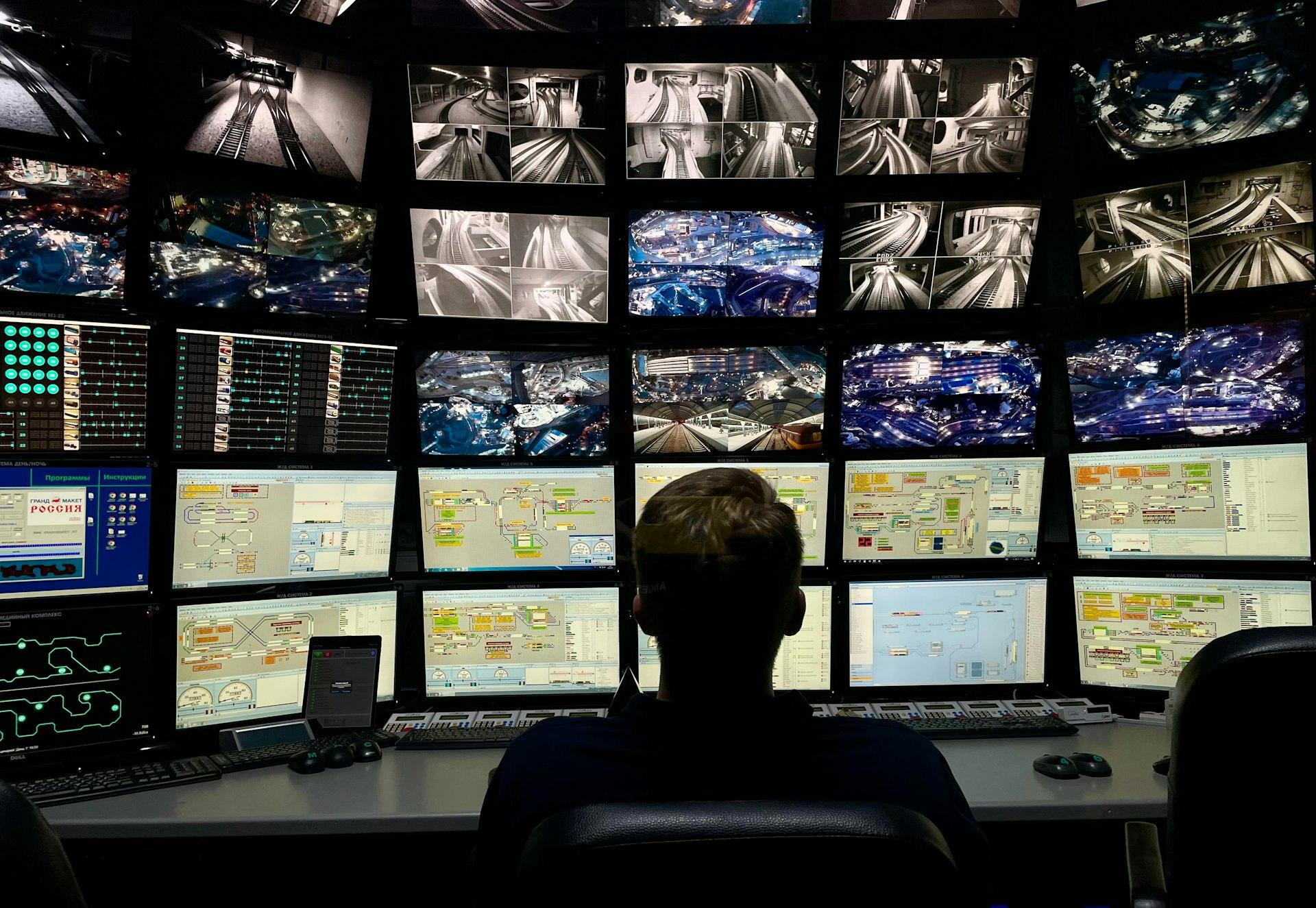 a man sitting in front of multiple monitors